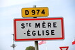 © Michael Derrer Fuchs - Road sign at entrance of French village of Sainte Mere Eglise on a summer day. Photo taken July 16th, 2026, Sainte Mere Eglise, France.