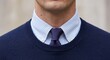 © tino - A detailed view of a man wearing a striped shirt, a textured blue tie, and a navy sweater. The image highlights a professional and polished style.