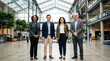 © Ayesha - Diverse group of business professionals standing in a modern office atrium hall