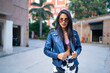© IndiaPix - A young woman standing outside wearing a crop top and leather jacket .
