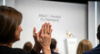 © soman - Audience members applaud during a corporate award ceremony presentation.