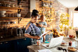 © Marko Geber - Mother with baby managing bills in home kitchen