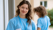 © YURII - Young healthcare volunteer standing at doorway with friendly smile providing community support and home care services