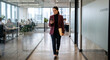 © Kudrat - Businesswoman walking in office using smartphone. Professional female employee checking phone.