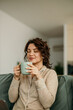 © La Famiglia - Woman enjoying morning coffee at home feeling relaxed