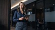 © Eve - Smiling professional businesswoman holding digital tablet standing in modern corporate office interior, elegant mature female executive looking away confident, career success concept.