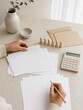 © Elena - Woman holding blank paper with calculator and wooden figures. Planning budget and managing debt. Financial accounting and household finance concept. Concept of economic trouble.