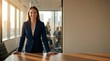 © Daniel - Businesswoman standing in modern office holding meeting. Professional leader ready to work during company conference with colleagues in background. Corporate career and leadership concept.