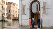 © Nei Mar - Group of four people chatting outside building by canal in Venice