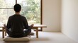 © Tetiana - Man Meditating Cross-Legged in Japanese-Style Room with Garden View Back View