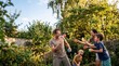 © Morrina - Kids and parents are tossing water balloons in a sunny backyard, playful laughter and summer holiday family togetherness