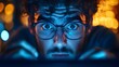 © ainynoer - Close-up of a young man with glasses intensely focused on a screen under blue light, eyes wide with tension or surprise, blurred warm bokeh background suggesting nighttime digital activity.