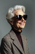 © ADDICTIVE STOCK - Stylish elderly woman in sunglasses and patterned jacket, smiling confidently