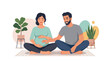 © Sri - A pregnant woman and her partner sitting together and touching her belly.