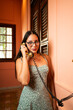 © ADDICTIVE STOCK - Young woman using vintage landline phone in cozy room