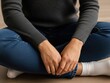 © aima - Woman sitting crosslegged on floor with hands on knees wearing jeans and socks