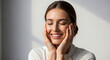 © MdMojibor - Beautiful young woman posing with eyes closed while touching cheeks with both hands expressing peaceful happiness and inner contentment inside.
