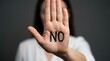 © SunSpirit - A woman's hand with the text NO written on the palm in a stop gesture.