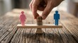 © Zaiseefa - Gender equality concept with pink female and blue male figures on a balanced seesaw