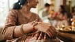 © velikiyzayats - Close up of an Indian woman wearing a decorative Rakhi bracelet on her wrist during a traditional festival celebration, festive ethnic attire and henna hand art