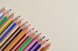 © E.R.Dora - Colored pencils arranged diagonally on a pastel yellow background.