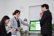 © PRIME STOCK LAB - Professional colleagues analyzing ESG data on computer monitor in a modern office meeting