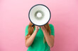 © luismolinero - Young blonde woman isolated on pink background shouting through a megaphone to announce something