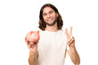 © luismolinero - Young handsome man holding a piggybank over isolated background smiling and showing victory sign