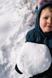 © Manu Padilla/Stocksy - Boy holding large snowball on a snowy winter day