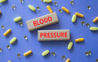 © Natallia - BLOOD PRESSURE symbol. Concept word BLOOD PRESSURE on wooden blocks. Beautiful purple background with pills. Medicine and BLOOD PRESSURE. Copy space