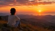 © Formoney - Woman sitting watching sunset over mountainous landscape at dusk