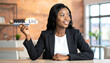 © tukang - Smiling Black woman in business suit holding blocks with 'work life' text, representing balance and harmony