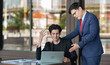 © BESTIMAGE - Stressed young businessman holding head in hand receiving criticism by manager after discussing document error on laptop for work mistake at outdoor office business pressure leadership feedback.