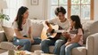 © mihrzn - A smiling father plays an acoustic guitar on a couch while his wife and daughter listen happily in their bright living room.
