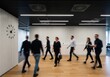 © NURUNNAHAR - Business people walking in modern office hallway
