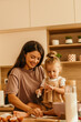 © La Famiglia - Mother and daughter baking cookies in kitchen enjoying family time