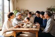 © Iis - Three Generations Sharing A Homemade Meal At A Wooden Dining Table