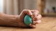 © otra - Hand Squeezing Blue Stress Ball on Wooden Table