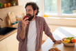 © Dexon Dee - Happy man eating apple in kitchen enjoying healthy snack