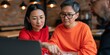 © Andrii Zastrozhnov - Diverse team reviewing laptop screen together in warm cafe for business meeting banner and collaborative workspace imagery