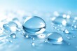 © mila103 - Small and large droplets of water sit on a flat surface. Light reflects off the droplets. The setting is bright and clear, highlighting the water's shape.