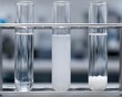 © Sekai - Precipitation reaction set with transparent test tubes showing clear cloudy settled stages chemistry education experiment