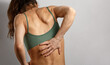 © Anastasia.photoyoga - Woman holding painful lower back with one hand in pain problem. Concept of lumbar pain, backache, muscle strain, physiotherapy, rehabilitation, healthcare and chronic pain