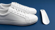 © AI_Nusantara - Classic White Sneakers Paired with a Sleek White Shoe Horn on a Deep Blue Background Symbolizing Footwear Fashion and Ease of Use