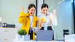 © R Photography - Two happy businesswomen celebrating success at a laptop in a modern office