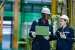 © Wanwajee - Industrial engineers collaborate using laptop and walkie talkie during machine inspection inside manufacturing plant. Technical communication, preventive maintenance, factory operations.
