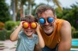 © zhuan - playful man and young boy by a backyard pool, boy peering through an orange toy while both smile amid tropical palms and lush garden