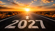 © MI - Asphalt road leading to the horizon with 2027 painted on the ground at a beautiful golden sunset.