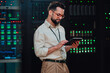 © Zamrznuti tonovi - It technician monitoring server data performance using a tablet in a modern data center with glowing racks