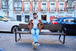© Oscar - Young man relaxing on city bench in winter jacket
